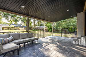 Wooden terrace with outdoor lounge area and a fenced backyard