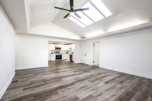Unfurnished living room with a ceiling fan and dark wood finished floors