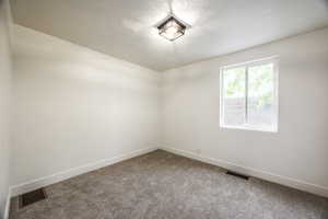 Unfurnished room featuring carpet floors and a textured ceiling