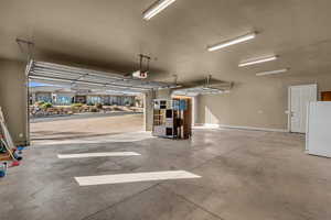 Garage with freestanding refrigerator and baseboards