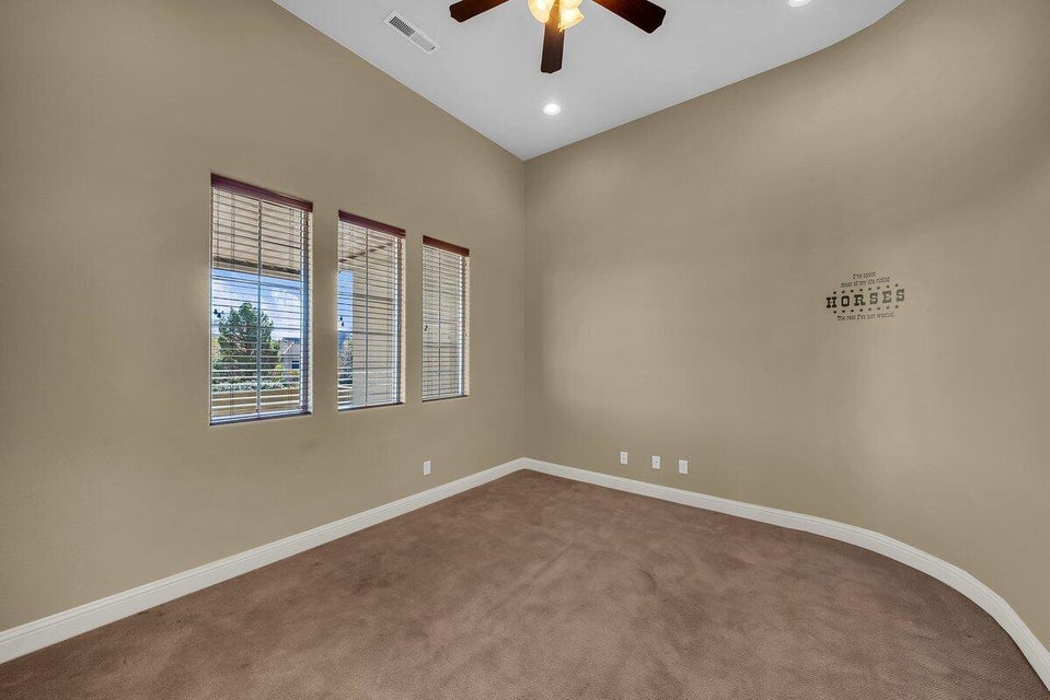 Carpeted spare room with ceiling fan, a high ceiling, and recessed lighting