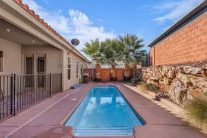 View of pool with a fenced backyard and patio surround