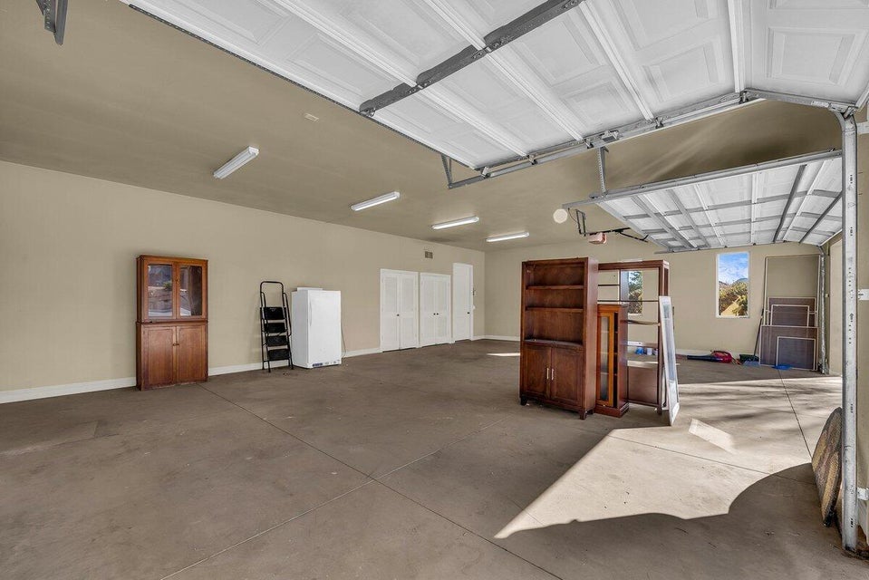 Garage featuring freestanding refrigerator and baseboards