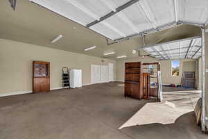 Garage featuring freestanding refrigerator and baseboards
