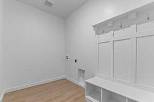 Laundry area with light wood finished floors, electric dryer hookup, and hookup for a washing machine
