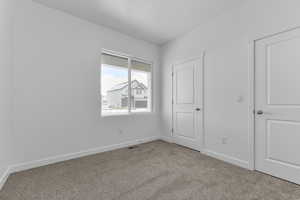 Unfurnished bedroom with baseboards and carpet flooring