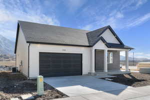 Modern farmhouse featuring a mountain view, a porch, roof with shingles, and driveway