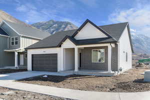 View of front of house featuring a mountain view, a porch, an attached garage, and roof with shingles