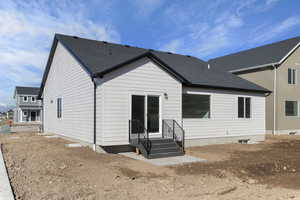 Rear view of property with a shingled roof and entry steps