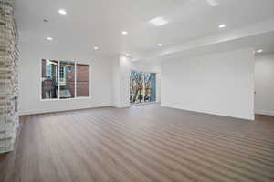 Unfurnished living room with dark wood-type flooring and recessed lighting