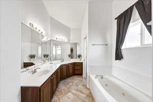 Full bathroom with double vanity, a whirlpool tub, and light marble finish floors