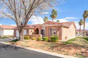 Mediterranean / spanish-style house with stucco siding, a tiled roof, a garage, and driveway