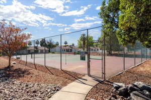 View of tennis court featuring a gate and a residential view