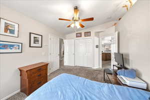 Bedroom with carpet, vaulted ceiling, a closet, and a ceiling fan