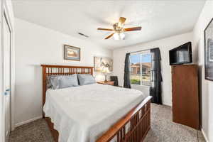 Bedroom with light carpet and a ceiling fan