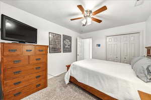 Bedroom featuring light colored carpet, a closet, and ceiling fan