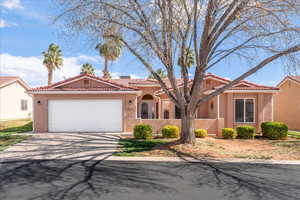 Mediterranean / spanish-style home with driveway, a tiled roof, an attached garage, and stucco siding