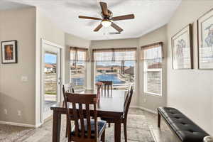 Dining area with a ceiling fan, plenty of natural light, and a textured ceiling