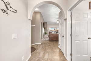 Hallway with a textured ceiling and arched walkways