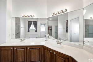 Full bath featuring a garden tub, double vanity, and a stall shower