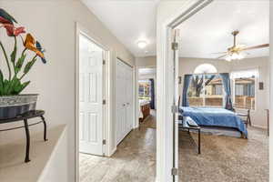 Bedroom featuring a closet, light carpet, and a ceiling fan