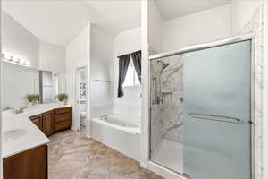 Full bathroom featuring double vanity, a jetted tub, and a marble finish shower