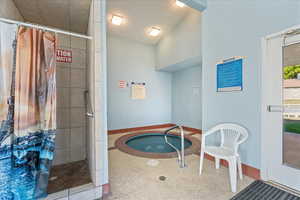 View of pool with a hot tub