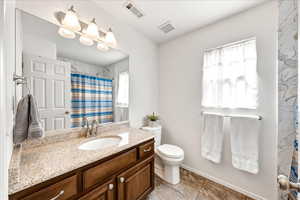 Full bathroom with vanity, a shower with shower curtain, and healthy amount of natural light