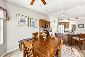 Dining space with ceiling fan and lofted ceiling