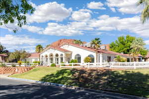 View of front of property featuring a fenced front yard, stucco siding, and a tiled roof