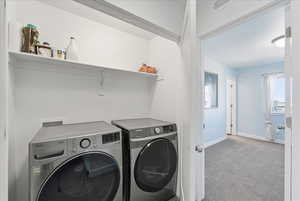 Laundry room featuring light colored carpet and independent washer and dryer