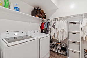 Laundry area featuring dark wood finished floors and washer and clothes dryer