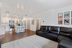 Living area featuring dark wood-type flooring and baseboards