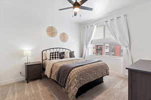 Bedroom with light carpet and a ceiling fan