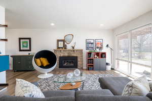 Living room featuring wood finished floors, a fireplace, and recessed lighting