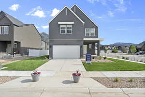 View of front facade with a residential view, stucco siding, an attached garage, and concrete driveway