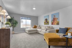 Carpeted living area featuring baseboards