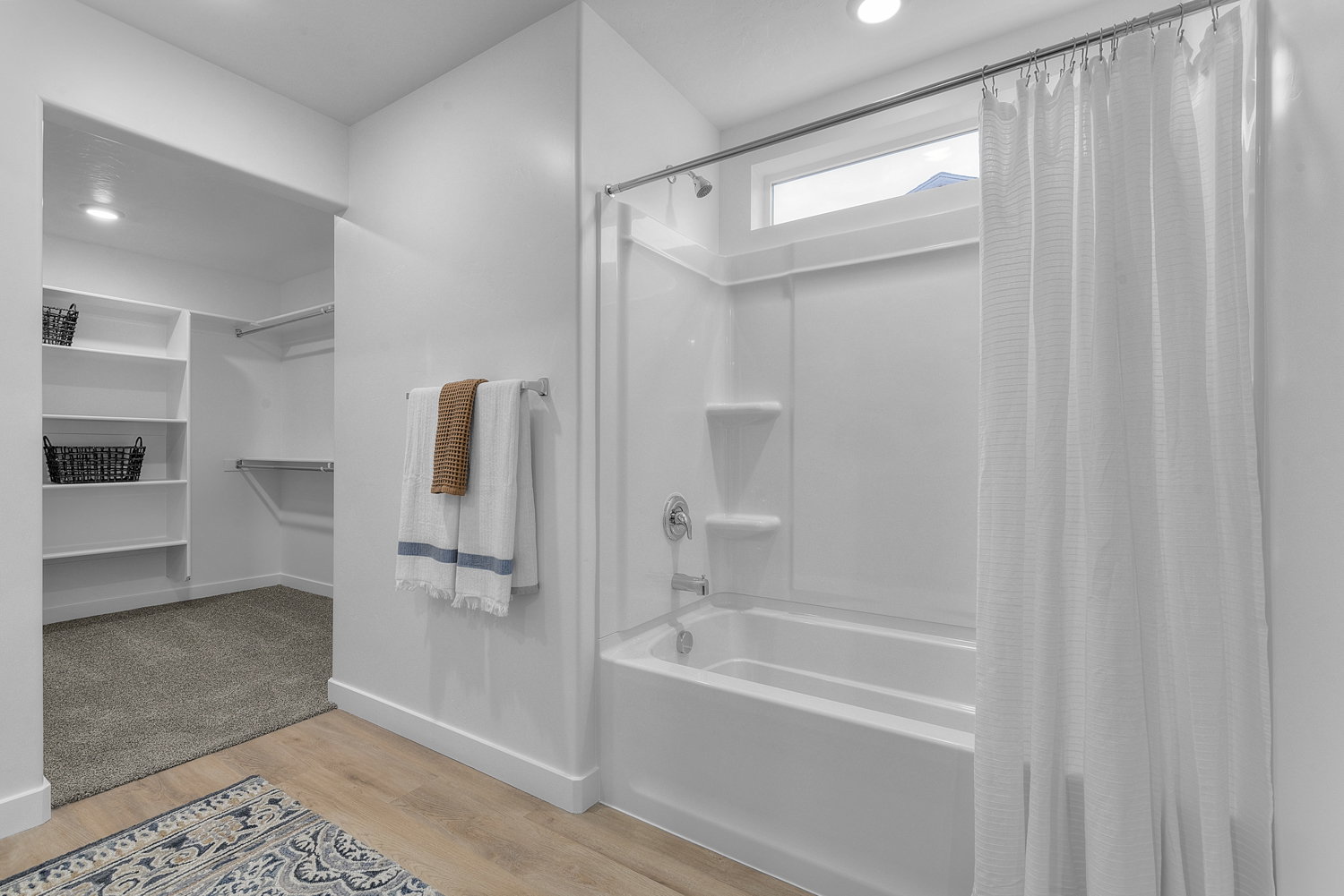Bathroom featuring light wood finished floors, a spacious closet, recessed lighting, and shower / tub combo with curtain