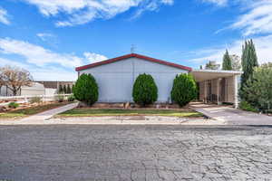 View of side of home featuring a carport and concrete driveway