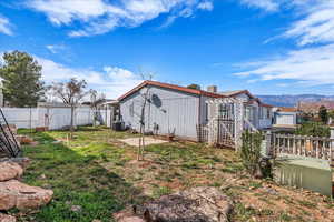 View of side of property with a fenced backyard, a mountain view, and a chimney