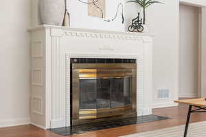 Detailed view of wood finished floors and a fireplace