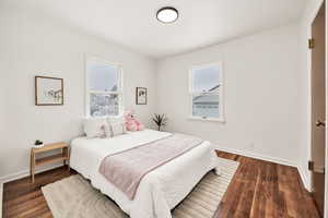 Bedroom featuring baseboards and wood flooring