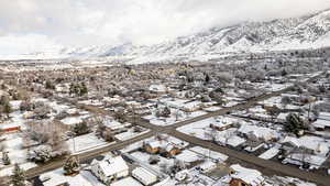 Snowy aerial view featuring a residential view and a mountain view