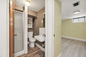 Bathroom with laminate flooring and a shower stall