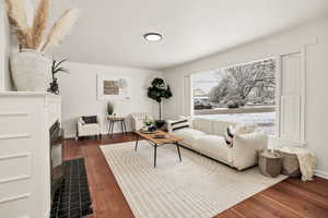 Living area with dark wood finished floors and a fireplace with flush hearth