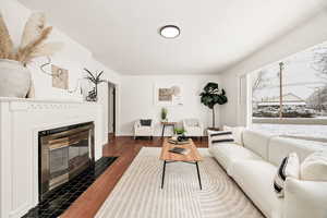 Living room featuring dark wood finished floors and a fireplace
