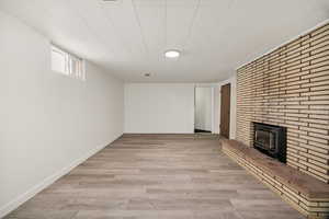 Basement featuring laminate flooring and a fireplace