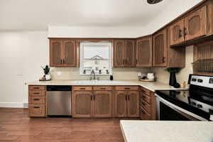 Kitchen featuring stainless steel appliances, light countertops, and dark wood-type flooring