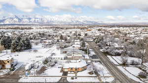 Snowy aerial view featuring a residential view and a mountain view