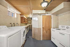 Laundry area featuring concrete floors and washing machine and dryer